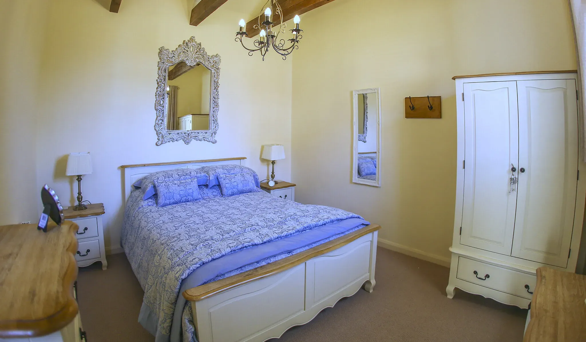 Chestnut Barn master bedroom with a kingsize bed, painted wardrobe and exposed beams